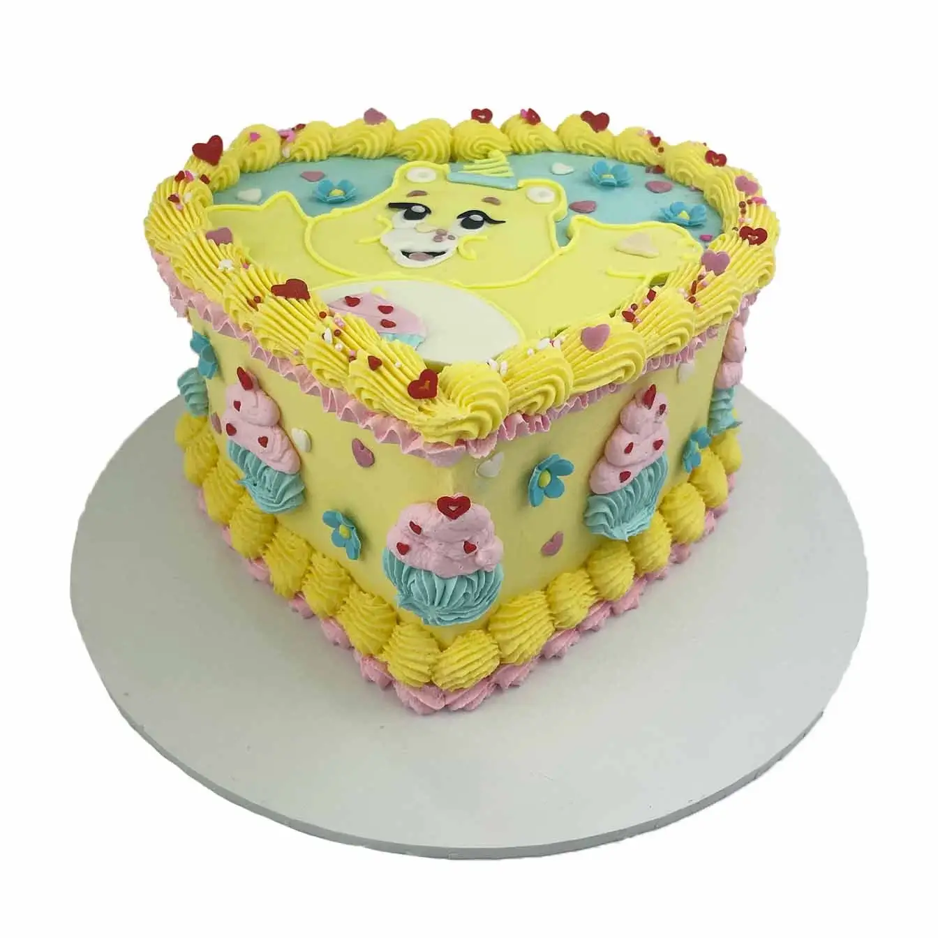 Yellow Care Bear Heart Cake - A heart-shaped cake with a cheerful yellow Care Bear, a lovable centerpiece celebrating the spirit of friendship and happiness!